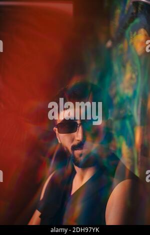 Portrait of young man wearing sunglasses at illuminated restaurant Stock Photo