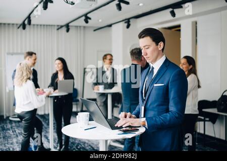 Businessman working over laptop while standing in office seminar Stock Photo