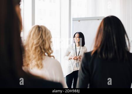 Female entrepreneur talking to colleagues in office seminar Stock Photo