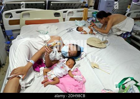 Manila, Philippines. 08th Dec, 2020. A mother lies next to her baby in the neonatal ward of the Jose Fabella Hospital, also known as 'baby factory'. This is one of the most frequented maternity wards in the world, which already has an even higher birth rate due to the Corona pandemic. Credit: Alejandro Ernesto/DPA/Alamy Live News Stock Photo