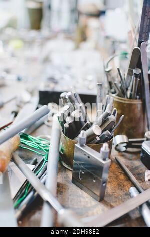 High angle view of various tools in container on workbench at jewelry workshop Stock Photo