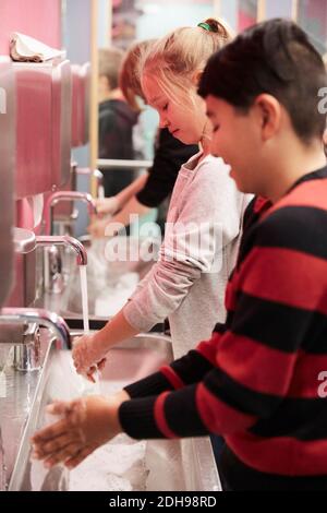 Junior high students washing hands in school Stock Photo