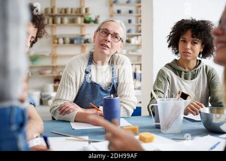 Female students listening sitting at table in art class Stock Photo