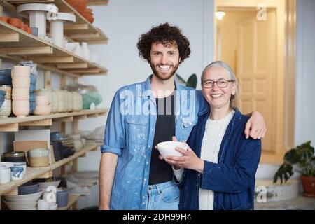 Portrait of smiling man and woman in pottery class Stock Photo