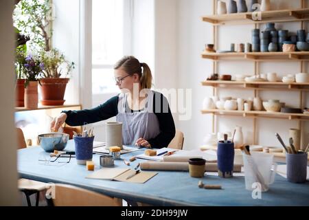 Young woman learning pottery in art class Stock Photo