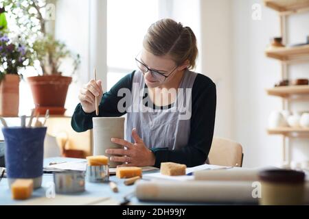 Young woman making earthenware in pottery class Stock Photo