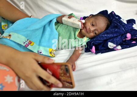 Manila, Philippines. 08th Dec, 2020. A mother uses a smartphone to film her baby at the neonatal ward of the Jose Fabella Hospital, also known as the 'baby factory'. This is one of the most frequented maternity wards in the world, which already has an even higher birth rate due to the Corona pandemic. Credit: Alejandro Ernesto/DPA/Alamy Live News Stock Photo