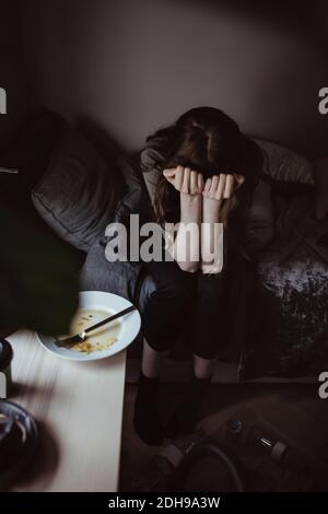 High angle view of sad woman sitting on bed Stock Photo