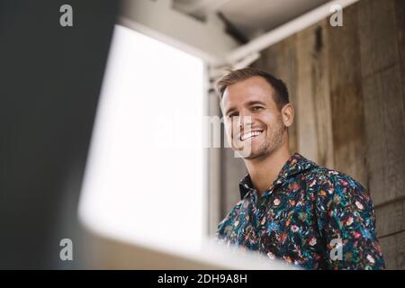 Low angle view of young businessman smiling in portable office truck Stock Photo