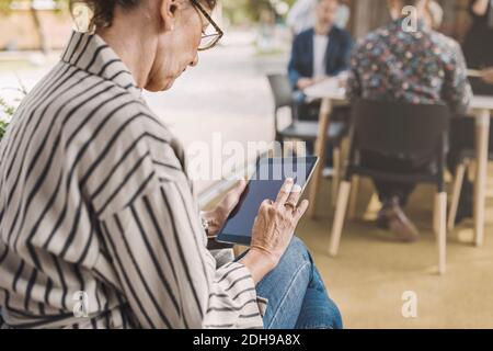 Senior businesswoman using digital tablet in portable office truck Stock Photo