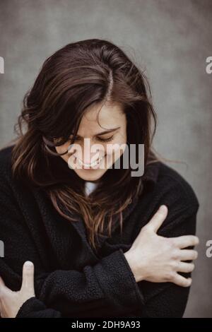 Happy woman with eyes closed standing outdoors Stock Photo