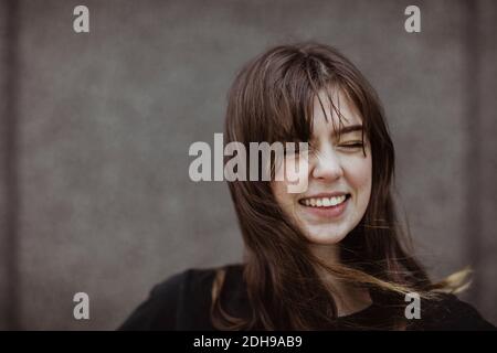 Happy woman with eyes closed standing outdoors Stock Photo