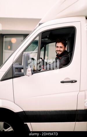 Portrait of smiling young delivery man driving truck Stock Photo