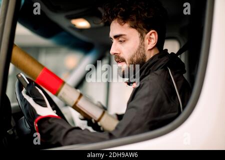 Young delivery man using mobile phone while driving truck Stock Photo
