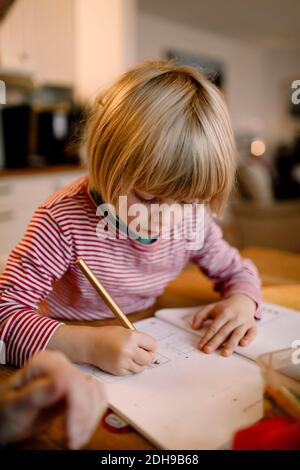 Boy doing homework at table Stock Photo