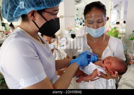 Manila, Philippines. 08th Dec, 2020. A nurse gives an infusion to a baby at the neonatal ward of Jose Fabella Hospital, also known as the 'baby factory. This is one of the busiest maternity wards in the world and already has an even higher birth rate due to the Corona pandemic. Credit: Alejandro Ernesto/DPA/Alamy Live News Stock Photo