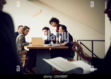 Team of multi-ethnic lawyers discussing strategy over laptop in meeting at office Stock Photo