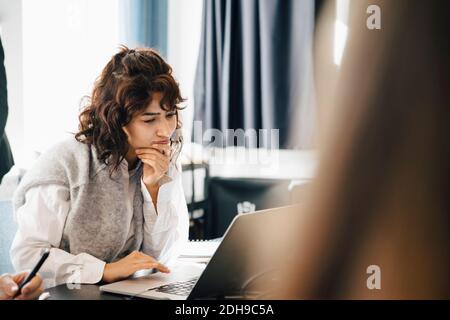 Businesswoman using laptop while sitting in board room Stock Photo