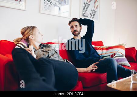 Couple talking while relaxing on sofa at home Stock Photo