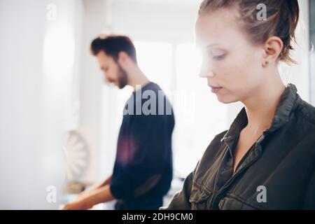 Side view of couple working in kitchen at home Stock Photo