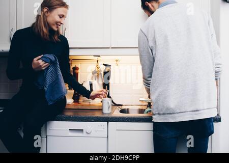 Couple washing dishes in kitchen at home Stock Photo