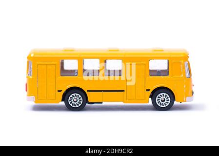 Plastic model of an old yellow bus, toy, miniature isolated on white Stock Photo