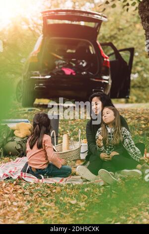 Mother and daughters enjoying picnic in autumn Stock Photo