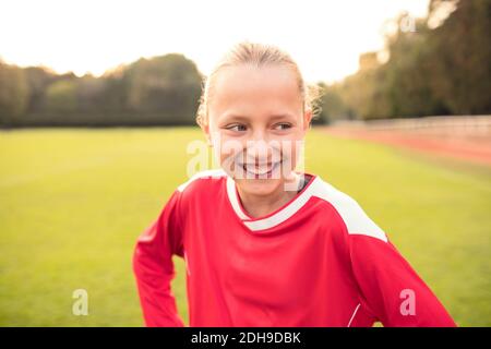 Happy soccer player looking away while standing on field Stock Photo