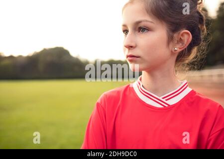 Female soccer player standing on field against sky Stock Photo