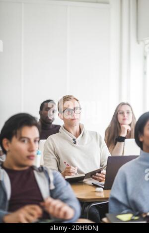 Young man sitting at desk in classroom Stock Photo