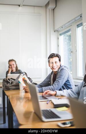 Smiling young man studying in university classroom Stock Photo