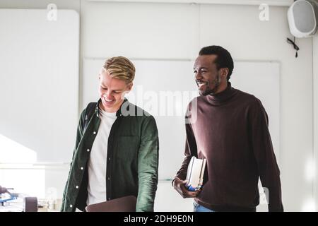 Smiling young male students in university classroom Stock Photo