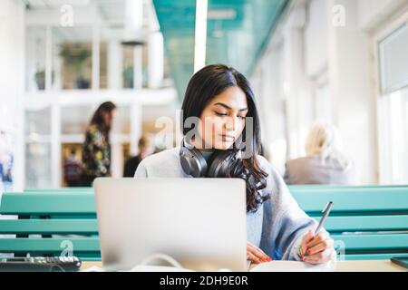 Young female student studying at cafeteria in university Stock Photo
