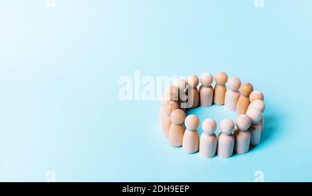 Concept of society, demography, groups, social ties. Discussion, problem solving. Association of people, cohesion. Wooden figurines in a circle on a b Stock Photo