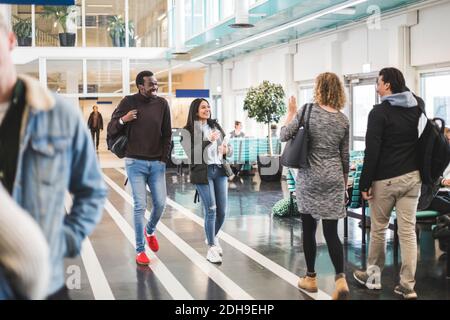 Young male and female students walking in cafeteria at university Stock Photo