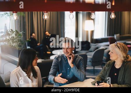 Businessman discussing with female colleagues in office Stock Photo