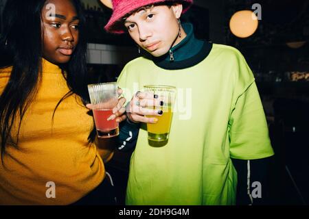 Portrait of man and woman with drinking glass standing at cafe Stock Photo