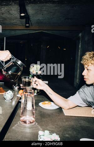 Cropped hand of young businessman pouring coffee for coworker in office Stock Photo