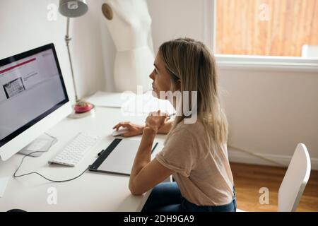 High angle view of female graphic designer using computer at desk in house Stock Photo