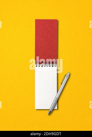 Blank open spiral notebook and pen isolated on yellow Stock Photo