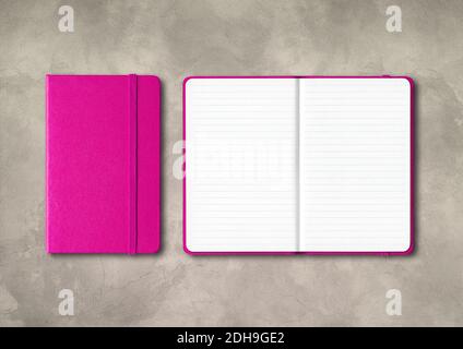 Pink closed and open lined notebooks on concrete background Stock Photo