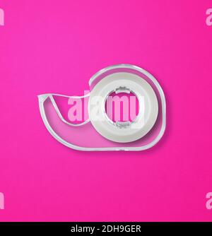 Scotch tape dispenser isolated on pink background Stock Photo