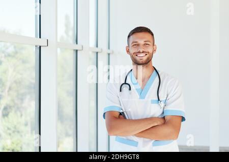 Portrait of confident smiling male doctor with stethoscope in medical uniform Stock Photo
