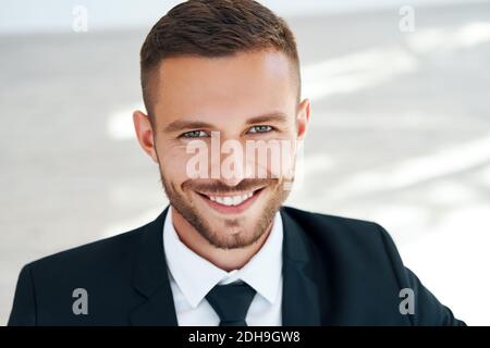 Close up portrait of handsome smiling young man in elegant suit Stock Photo