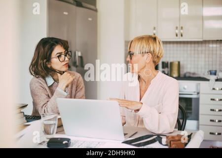 Two businesswomen having a conversation workin at home Stock Photo