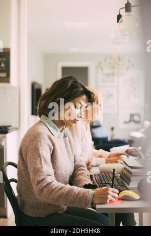 Two women working in living room at home Stock Photo