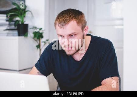 Young businessman using laptop in creative office Stock Photo