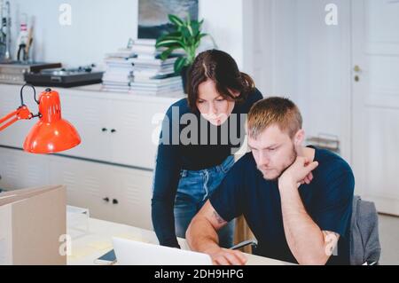 Business people using laptop at desk in creative office Stock Photo