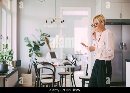 Woman working from home talking on the phone Stock Photo