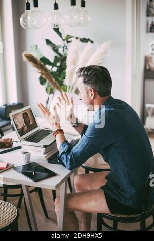 Aerial view of man having video chat with coworker at home Stock Photo